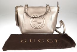Gucci- Soho Two way Bag, verfügt über eine Lederaußenseite in Metallic-/Champagnerfarbe  und silber