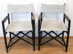 2 Regie-Stühle, schwarz gefaßtes, verstrebtes Holzgestell, klappbar, mit Leinenbezug, Gebrauchspure