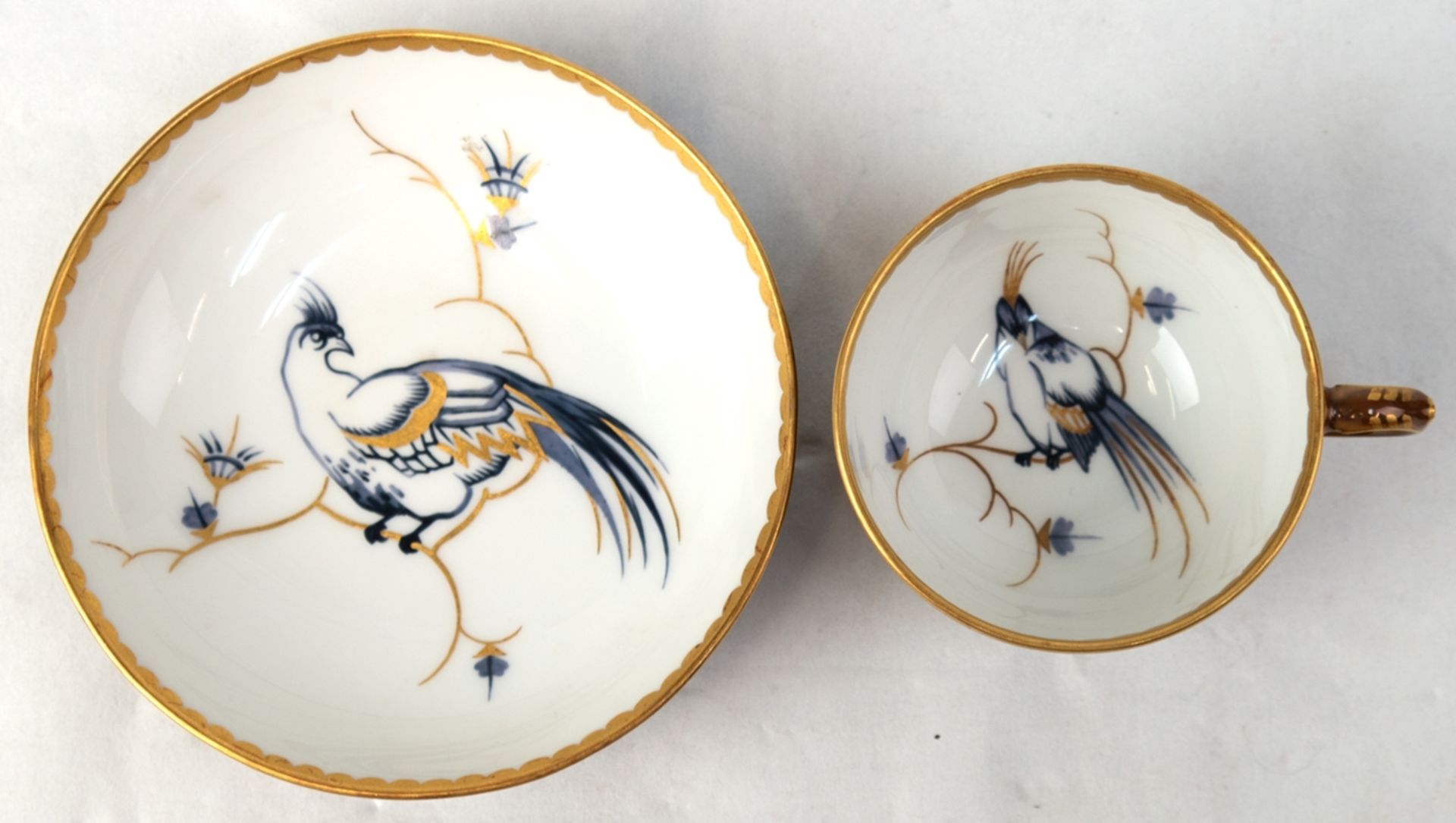 KPM-Tasse mit UT, braune Wandung, Tasseninnerers und UT mit Vogelmalerei in Grautönen mit Goldstaff