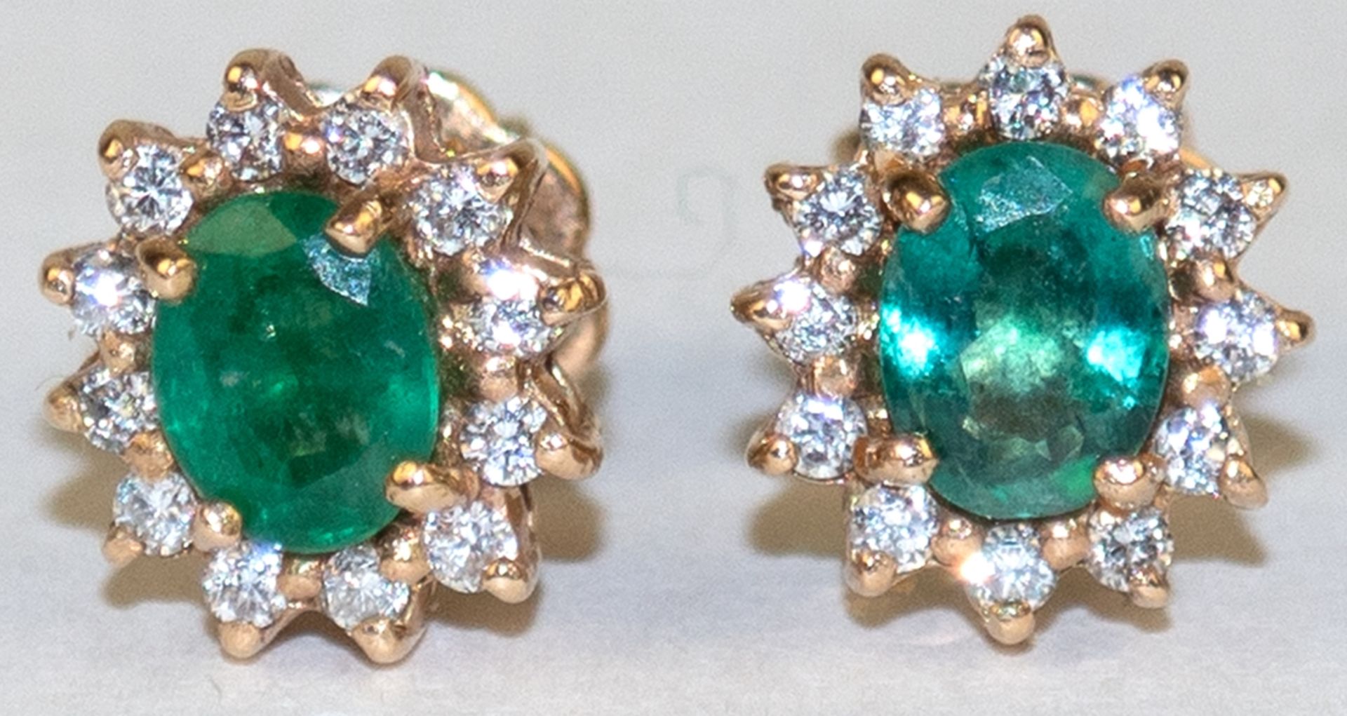 Ohrstecker, 585er GG, mit je oval facettiertem Smaragd, von 12 Diamanten eingefasst, ges. 2,1 g, Dm