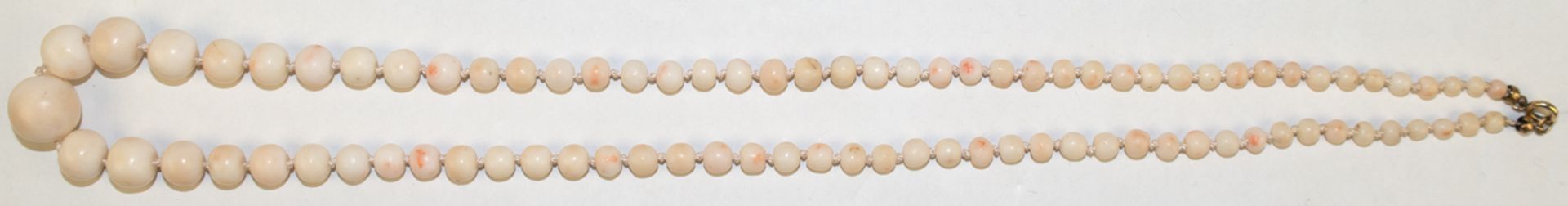 Kette, weiße Koralle, Perlen im Verlauf von ca. 1,5 cm - 0,4 cm, Länge ca. 65 cm