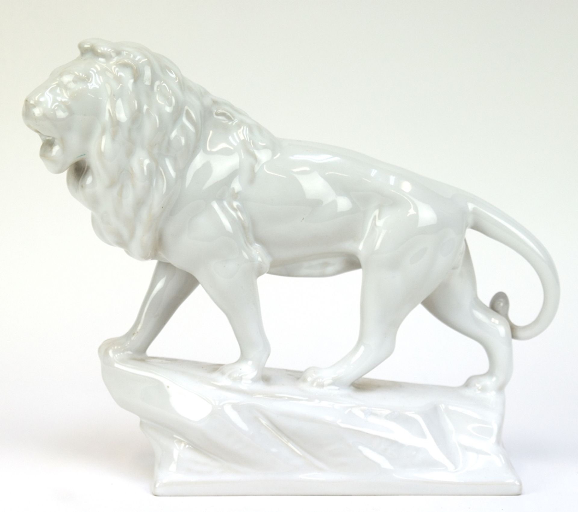 Figur "Schreitender Löwe", ungemarkt, auf naturalistischem Sockel unleserl. signiert, weiß glasiert