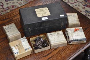 A leather box of musical instrument fittings, including reeds, violin strings, violin rosewood pegs,