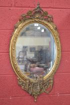A three light oval gilt girandole mirror, 103cm x 56cm