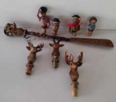 (7) wooden bottle stoppers together with a deer head shoe horn. Shipping Group (A).