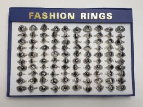 100 white metal fashion rings in presentation case. Shipping Group (A).