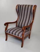 A good wingback armchair in the Biedermeier style. Upholstered in an elegant striped fabric.