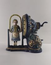 Cast metal money box in the form of a young girl skipping with rope, mechanical crank operation.