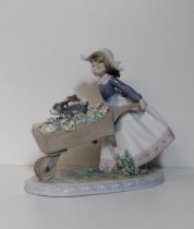 Lladro porcelain figure of a young girl pushing a barrow with flowers and two puppies, approx H:20