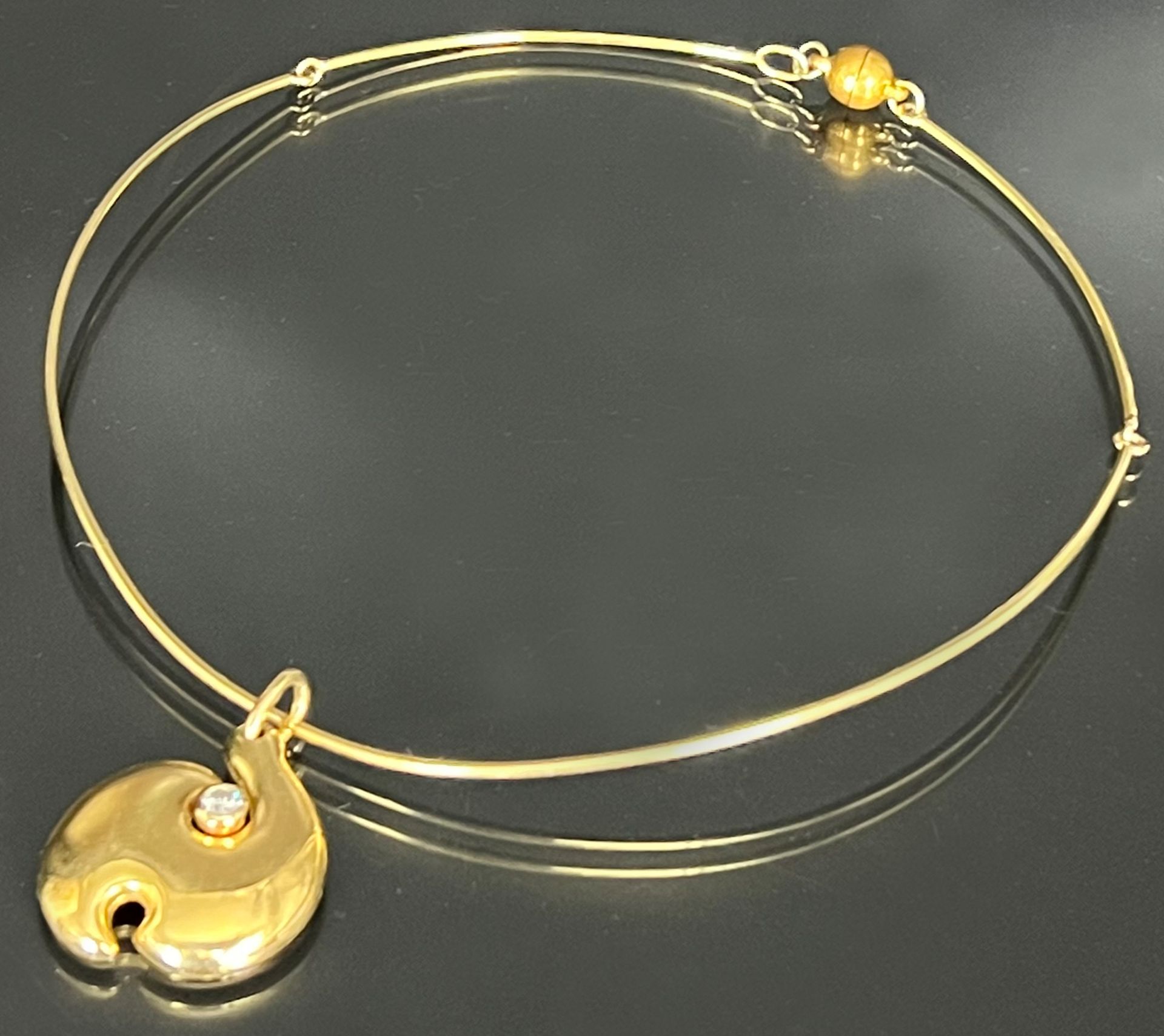 Necklace with a pendant made of gold of different alloys. Diamond of circa 0.15 ct.