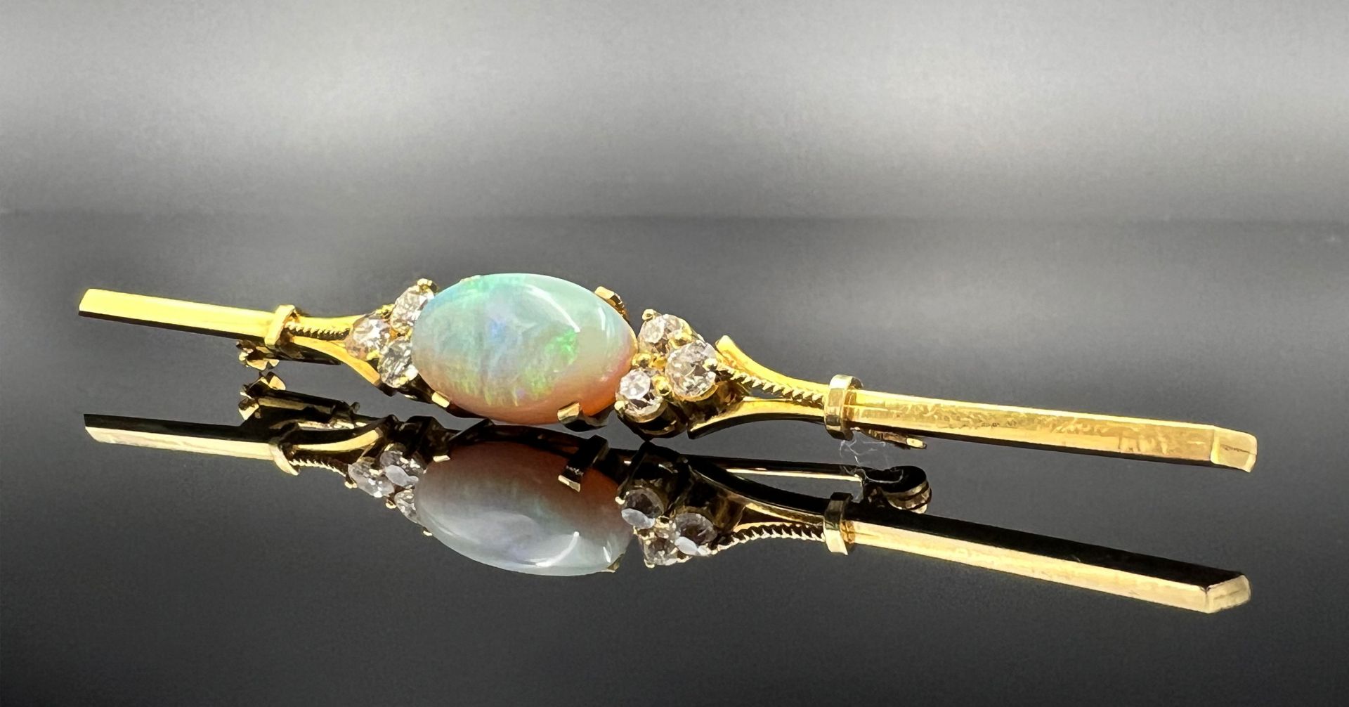 Bar brooch 750 yellow gold with an opal cabochon and six diamonds.