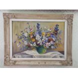 A 20th Century Oil on Canvas still life of wild flowers in a vase on a table setting. Indistinctly