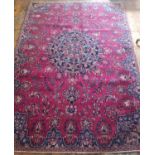 A Red ground Persian Carpet with a unique medallion design surrounded with a unique river blue