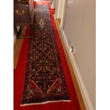 A long fine woven full pile Persian Surok Runner with a deep Red ground and unique all over