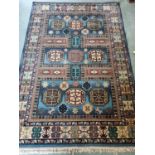 A blue ground New Zealand Wool Rug with unique central repeating medallions and multi borders. 240 x