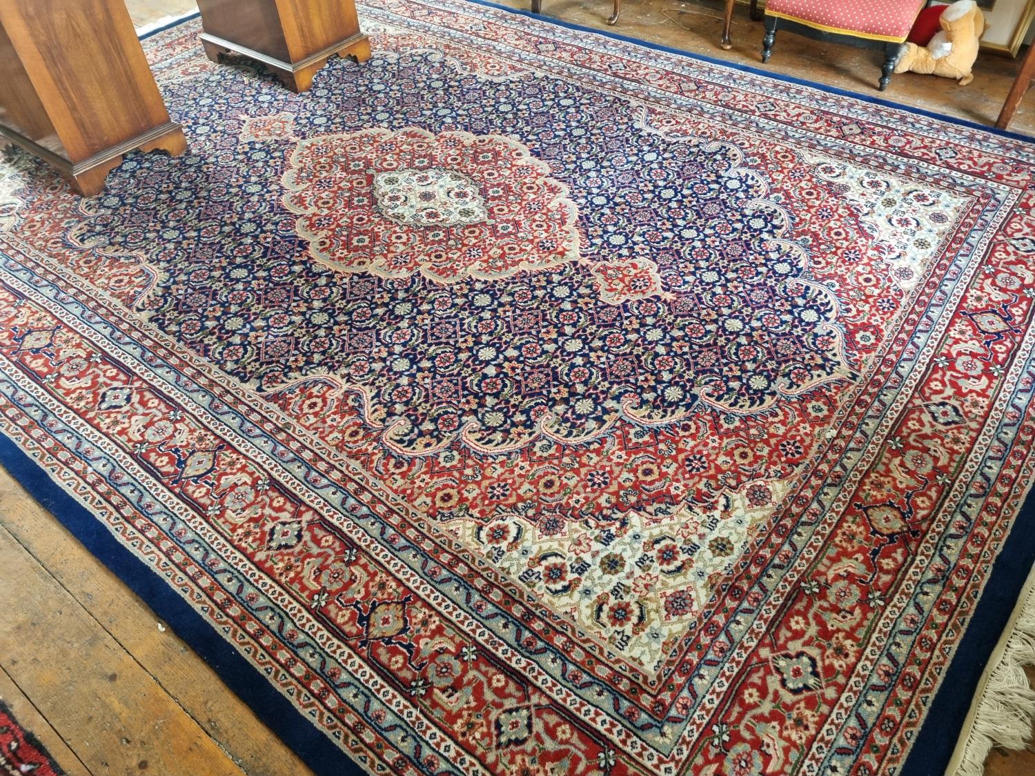A very large blue ground Hindu Persian Carpet with medallion design and multi borders.