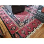 A red ground modern Carpet with Aztec style design. 240 x 340 cm approx.