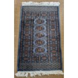 A small blue ground Rug with repeating medallion design and multi borders. 110 x 63cm approx.