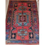 A Red ground Persian Hamadan Rug with a large medallion design. 190 x 130cm approx.