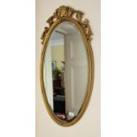 A good bevelled oval Gilt Mirror with carved cartouche top. 41 x 78 cm approx.