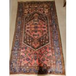 A pink ground Persian Hamadan Rug with a large medallion design. 225 x 128cm approx.