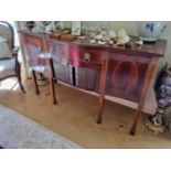 A late 19th Century serpentine fronted Sideboard with single frieze centre over twin tambour doors