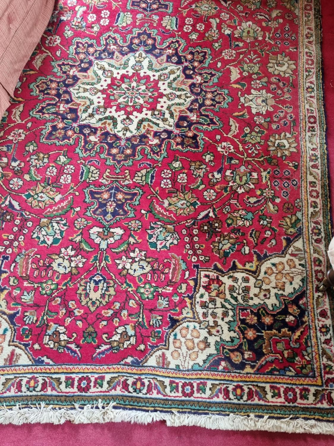 A good Persian Tabriz red and cream ground Rug with multi borders and unique central medallion