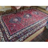 A good red and cream ground Persian Qashqai tribal Carpet with unique triple medallion design and