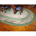 A Fantastic oval green ground Donegal Carpet with multi borders and swagged interior. 570 x 338 cm