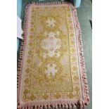 An unusual cream and pink ground Rug with tasselled edge. 203x110cm approx.