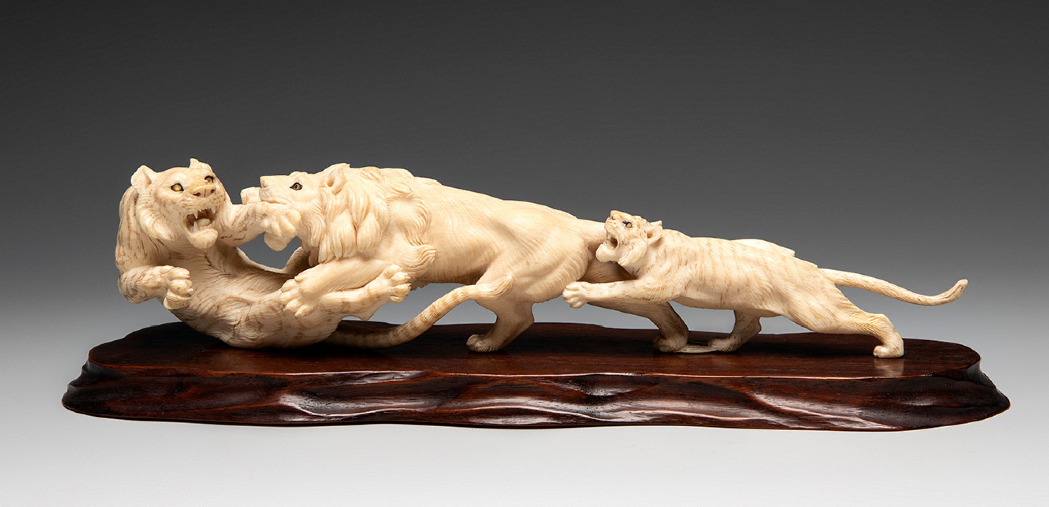 Enraged beasts. Japan, Meiji period, 19th century.Signed on the reverse.On carved wooden base.Weight