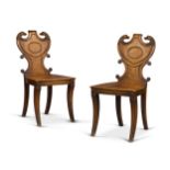 A pair of Regency carved mahogany hall chairs, first quarter 19th century