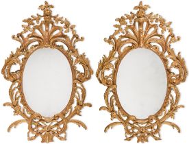 A pair of George III carved giltwood oval mirrors, circa 1765