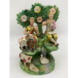A STAFFORDSHIRE BOCAGE GROUP DEPICTING TWO FIGURES AND VARIOUS ANIMALS AGAINST A LEAFY BACKGROUND