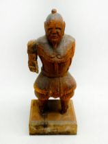 A LARGE CARVED WOODEN SAMURAI IN ARMOUR IN THE STYLE OF POSSIBLY LATE MUROMACHI PERIOD 16th CENTURY