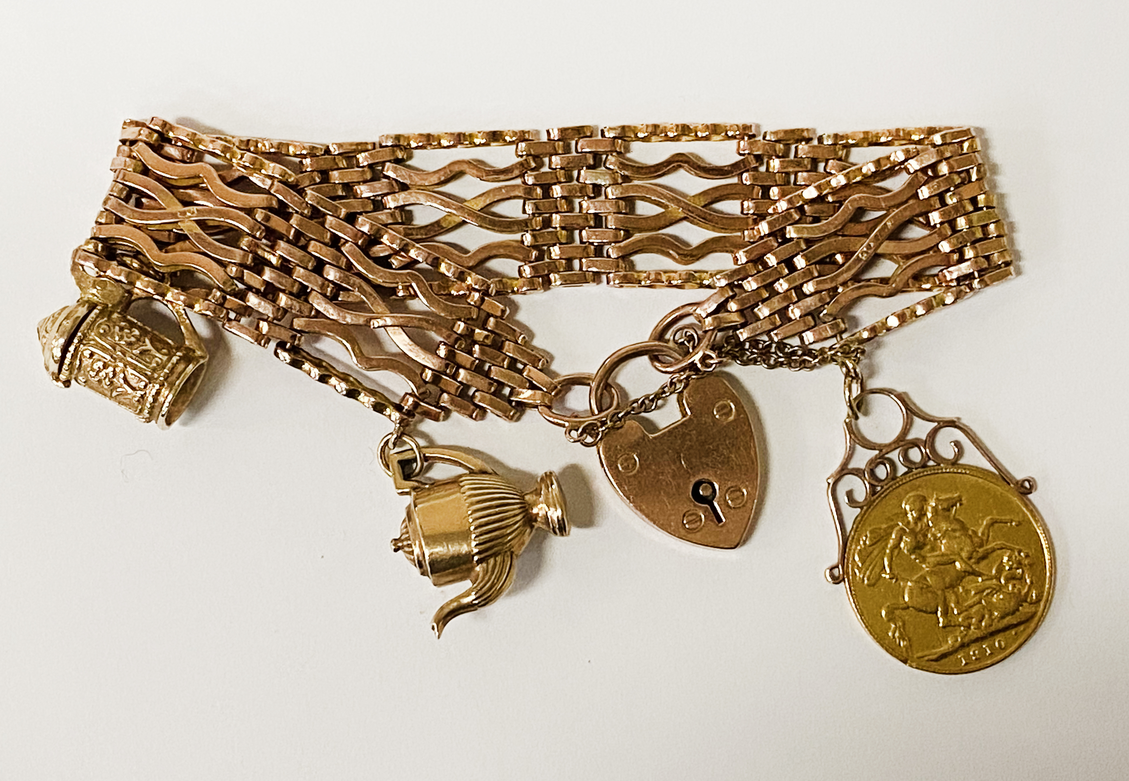 GOLD SOVEREIGN -1910 WITH MOUNT ON 9CT GOLD GATE BRACELET & CHARMS APPROX 46 GRAMS TOTAL