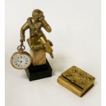 BRASS WATCH DESIGN PILL BOX WITH A BRASS FIGURAL SEATED BOY ON PLINTH WITH AN ENAMELLED POCKET