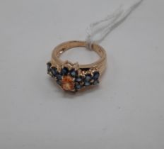 9CT GOLD BLUE SAPPHIRE WITH ORANGE SAPPGIRE TO CENTRE, RING - SIZE M - APPROX 4.8 GRAMS
