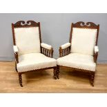 An Edwardian pair of mahogany framed arm chairs, reupholstered in cream upholstery,