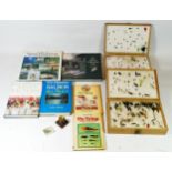 A collection of fishing flies, cased, together with associated hardback books, collector plates