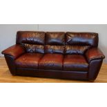 A three piece suite, red wine leather, comprising of a three seater sofa, 200cm x 75cm x 90cm, a two