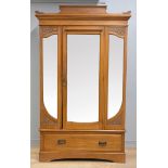 A double lightwood wardrobe, with carved wood decoration, tri-mirror front, bevelled, with lower