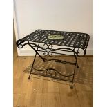 A modern cast metal and wrought iron table folding garden table, with inset floral plaque,