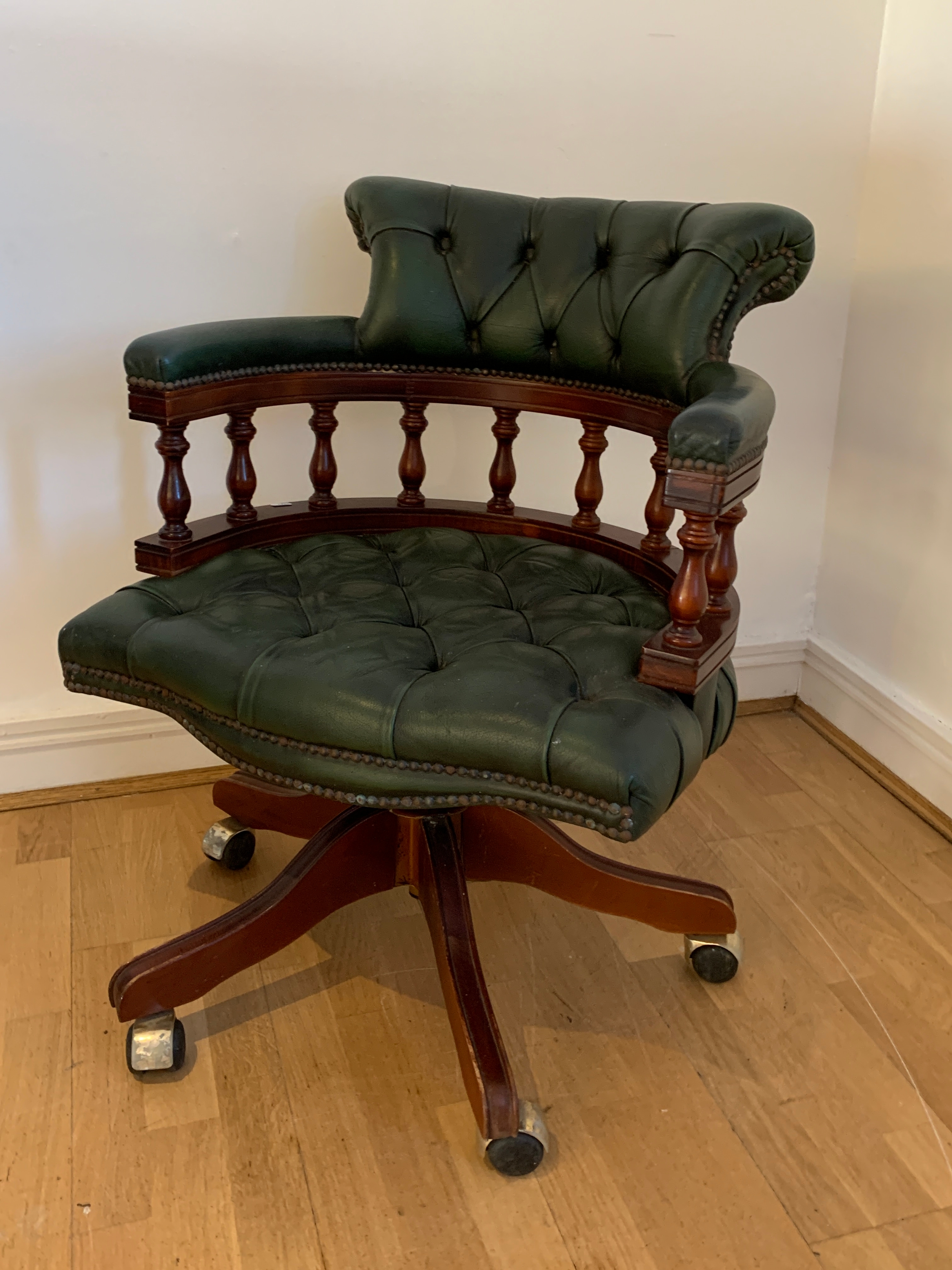 A mahogany framed green leather button back captain's chair by Ring Mekanikk, Norway, with swivel