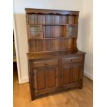 Modern light wood kitchen dresser with glazed top section over a base with two drawers and two