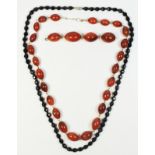 A French jet facetted glass bead necklace and a red glass graduated bead necklace