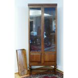 A free standing oak bookcase, having two glazed doors opening to four adjustable shelves, raised