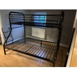 A child's metal framed bunk bed, with a single bed over a double, black powder coated frame Stock