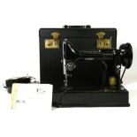 An early 20th century electric Singer sewing machine, model 221K, complete with original hard case.