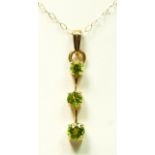 A 9ct gold and graduated peridot set pendant, 30mm, chain, 1.9gm